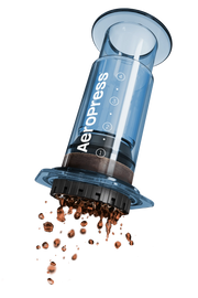 A red AeroPress coffee maker with a transparent chamber and a white filter filled with coffee grounds.