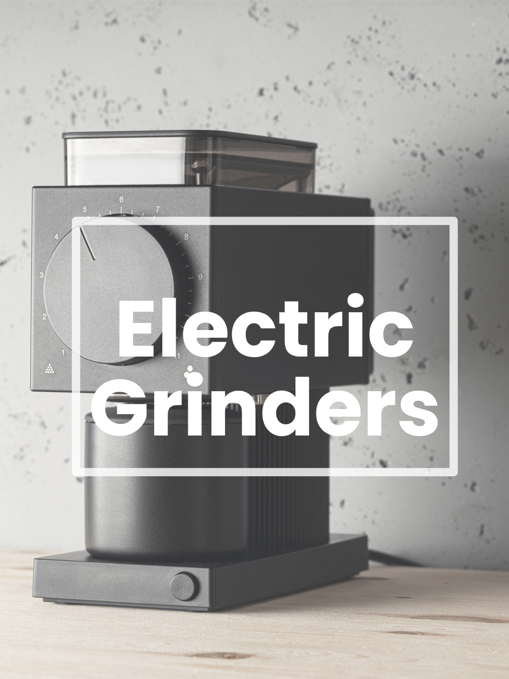 Electric grinder on a wooden surface with a gray speckled wall background